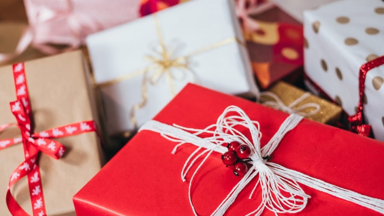 Red Christmas present with other colorful Christmas presents in the background